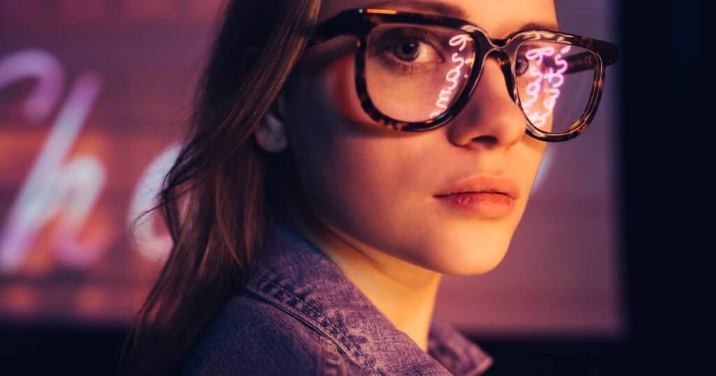 Kobieta w oryginalnych okularach, podkreślająca nowoczesny styl i atmosferę w salonie Optyk Szuka widzenia optyk jelenia góra.