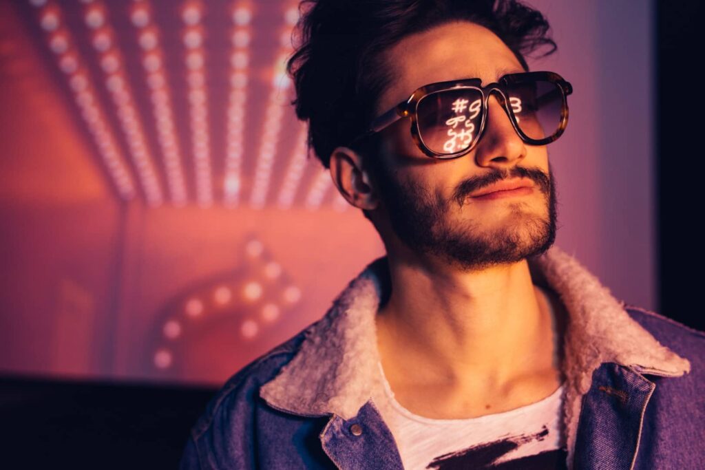 Mężczyzna noszący dżinsową kurtkę i okulary przeciwsłoneczne, prezentujący stylowy wygląd.